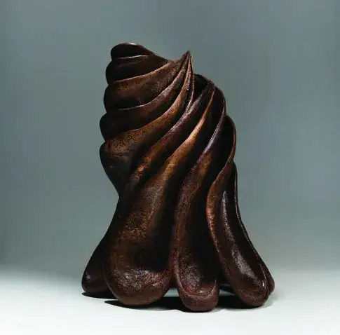 Escultura em bronze escuro de forma espiralada com bordas onduladas